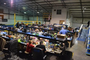 Drivers work on their cars between races. Each table features an overhead lamp and several plenty of electrical outlets.